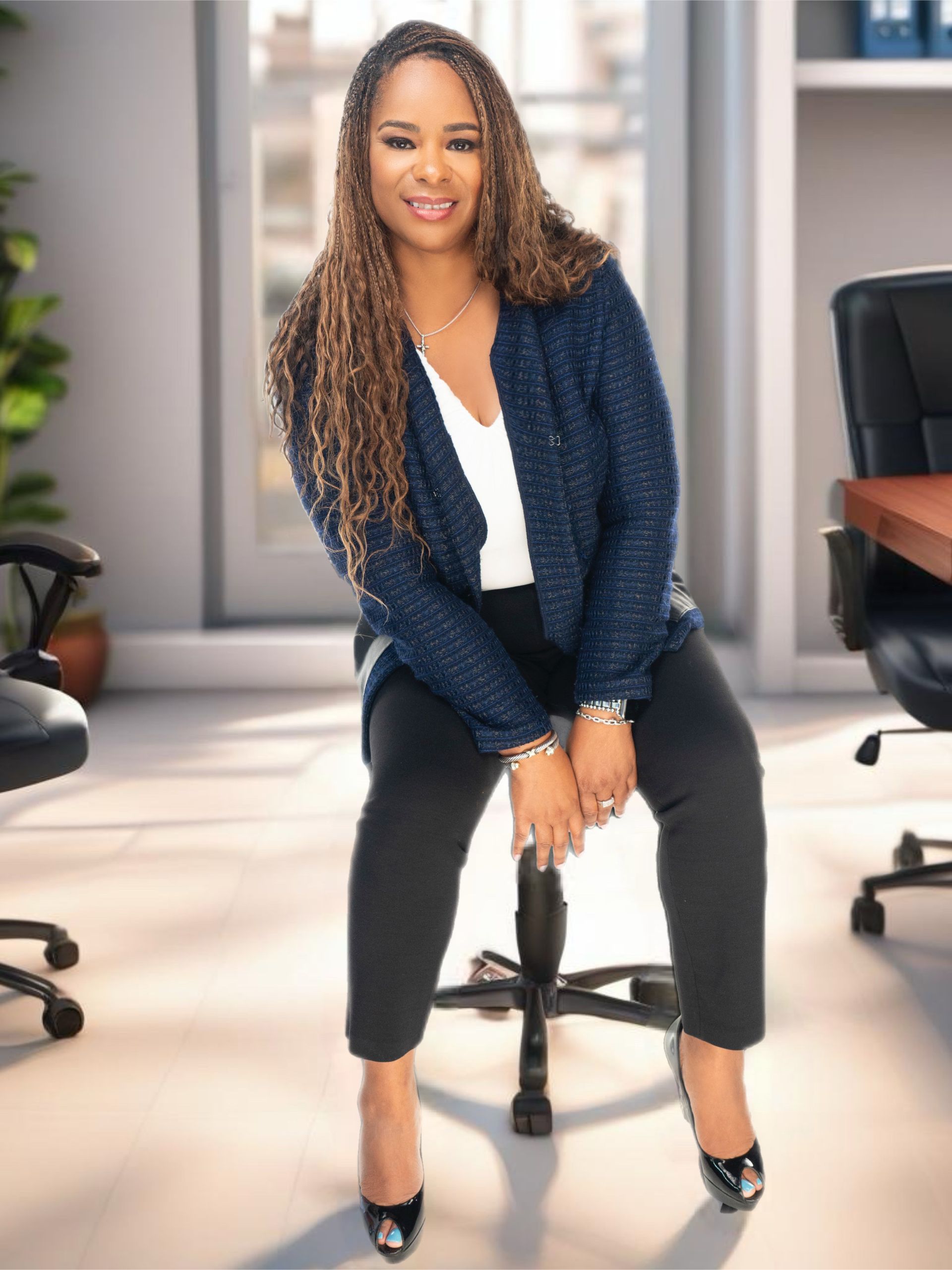 Coach Shermaine is sitting on a chair in an office.