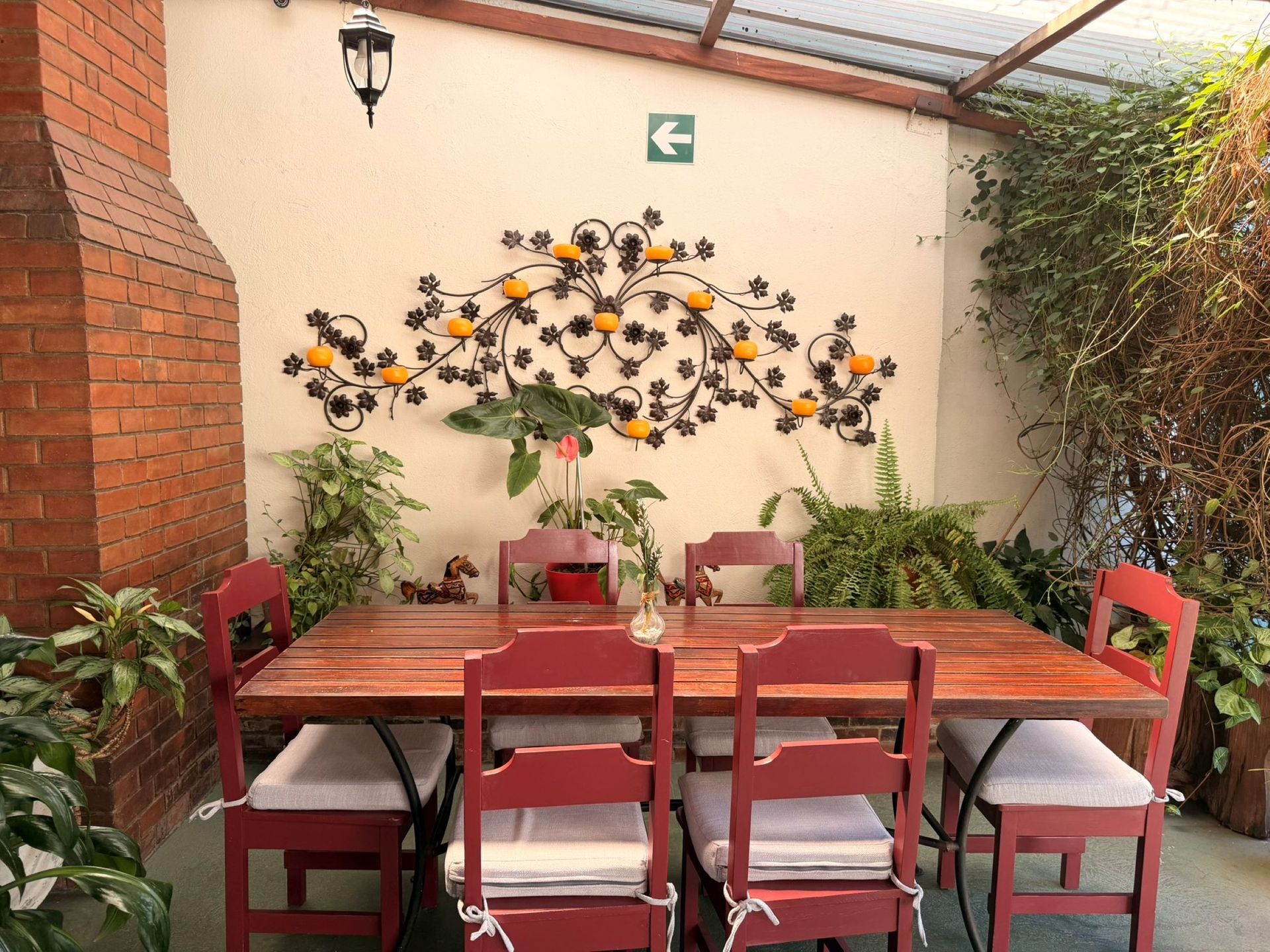 Acogedor salón con paneles de madera, sofá, sillón, lámpara, armario y gran ventanal con vistas a la vegetación.