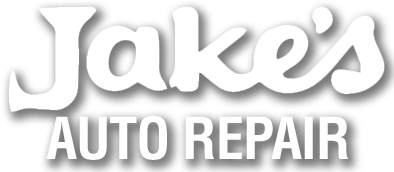 The logo for jake 's auto repair is white and has a shadow.