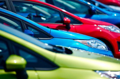 A row of colorful cars are parked next to each other.