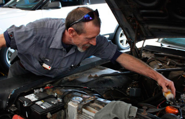 A man is working under the hood of a car