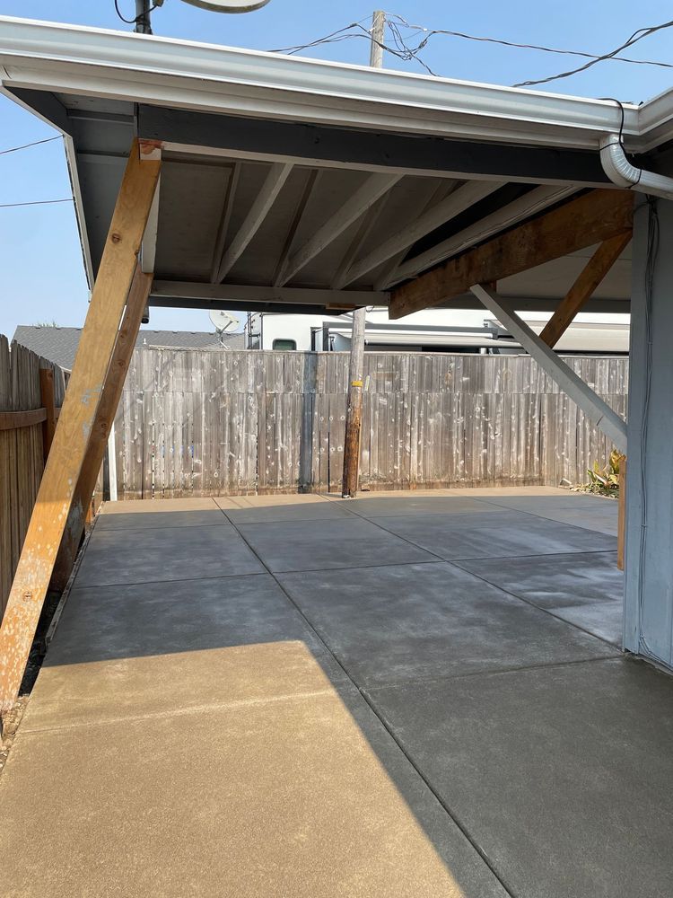 A carport with a wooden fence in the background.