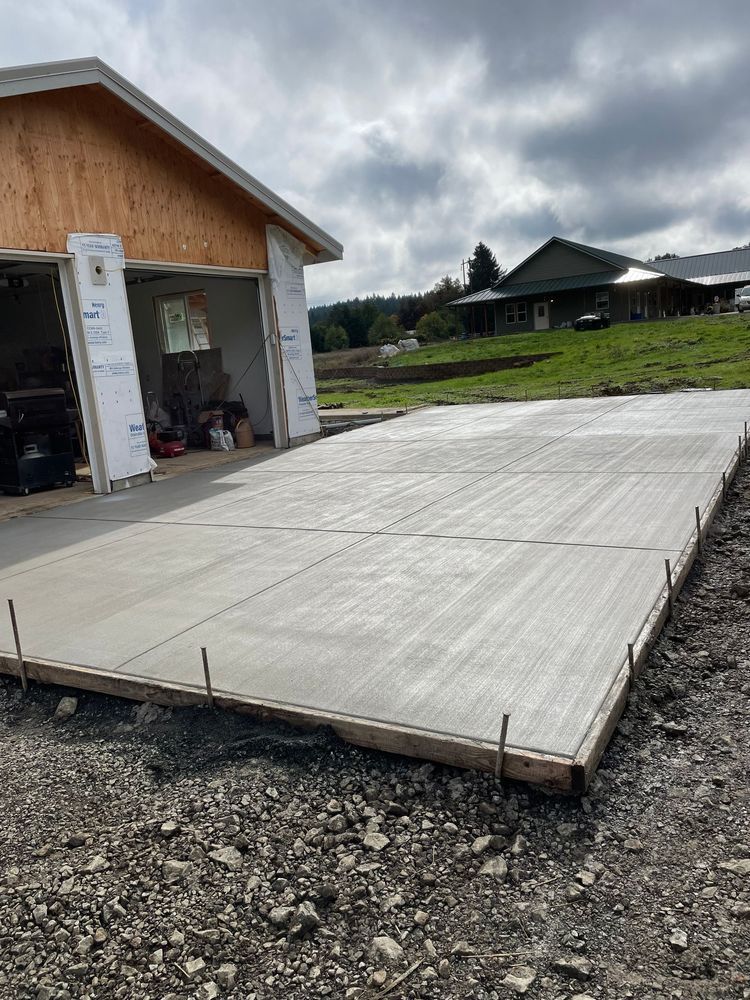 A concrete driveway is being built in front of a garage.