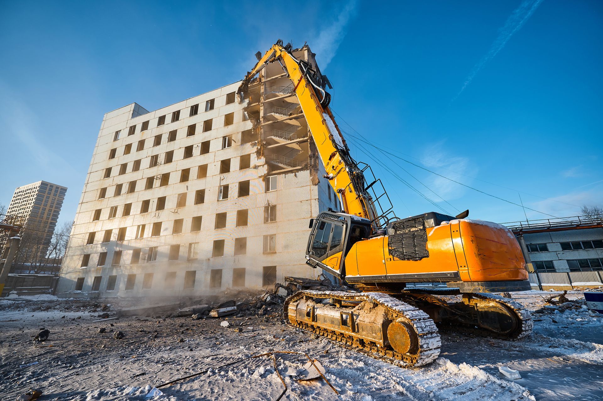 Residential demolition contractor using excavator to tear down large building structure. Residential demolition contractor using excavator to tear down large building structure.