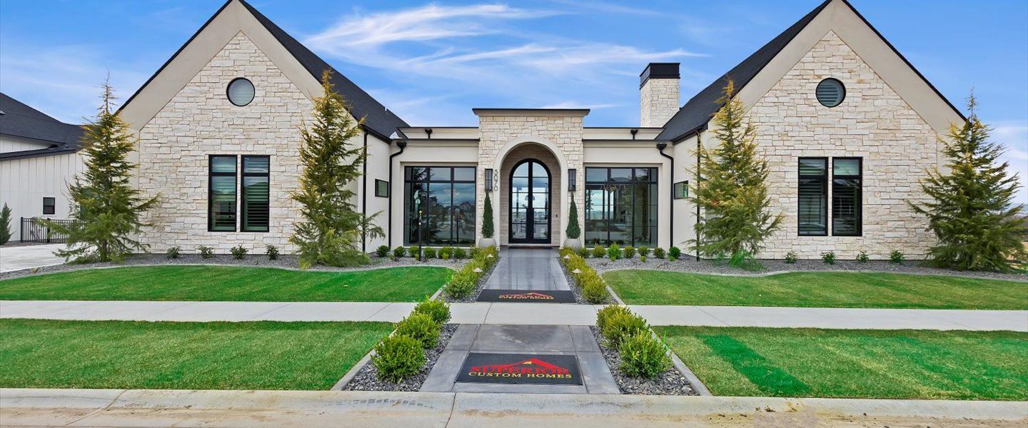 A large brick house with a lush green lawn in front of it.
