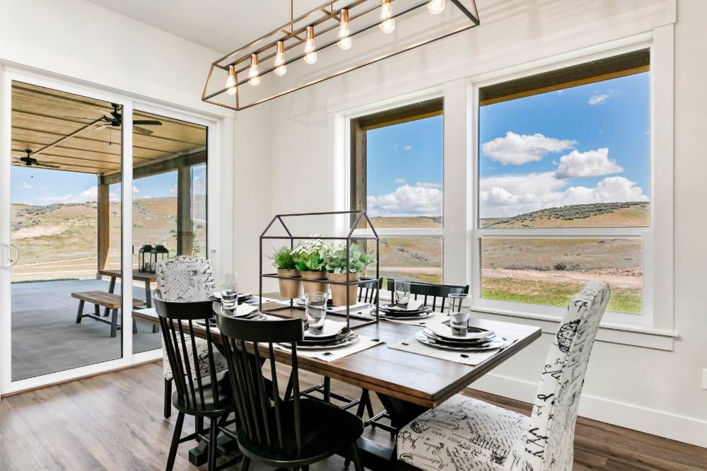 A dining room with a table and chairs and a large window.
