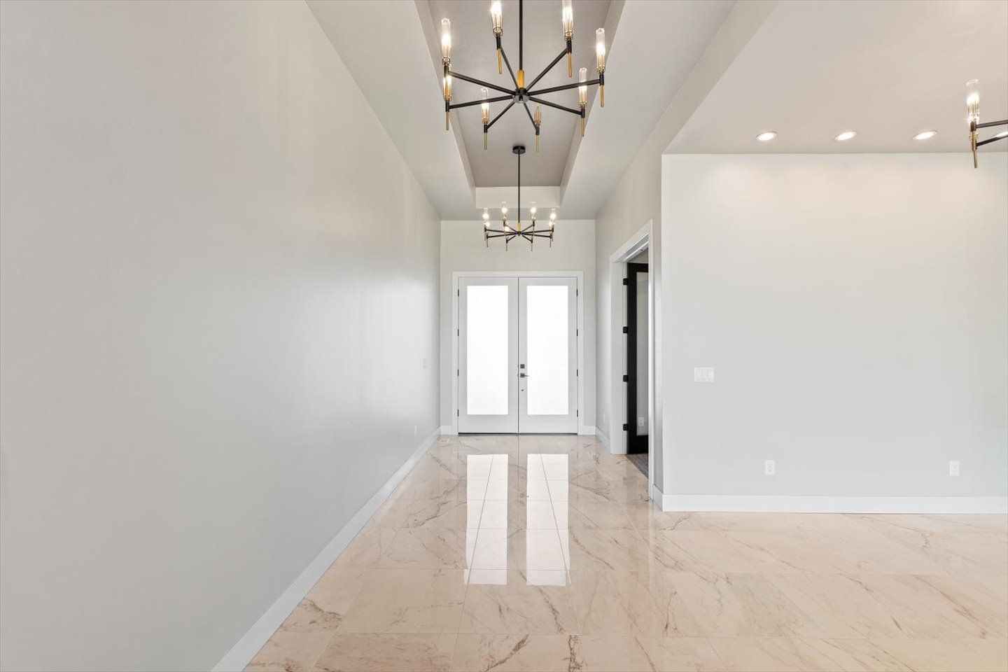A large empty room with a chandelier hanging from the ceiling.