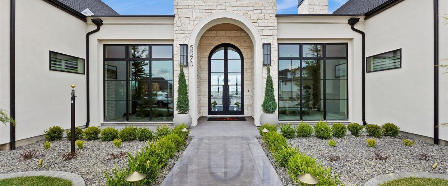 A large white house with a walkway leading to the front door.