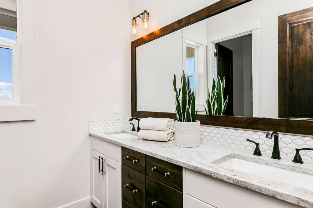 A bathroom with two sinks and a large mirror.
