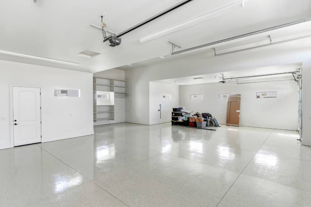 A large empty garage with white walls and a shiny floor.