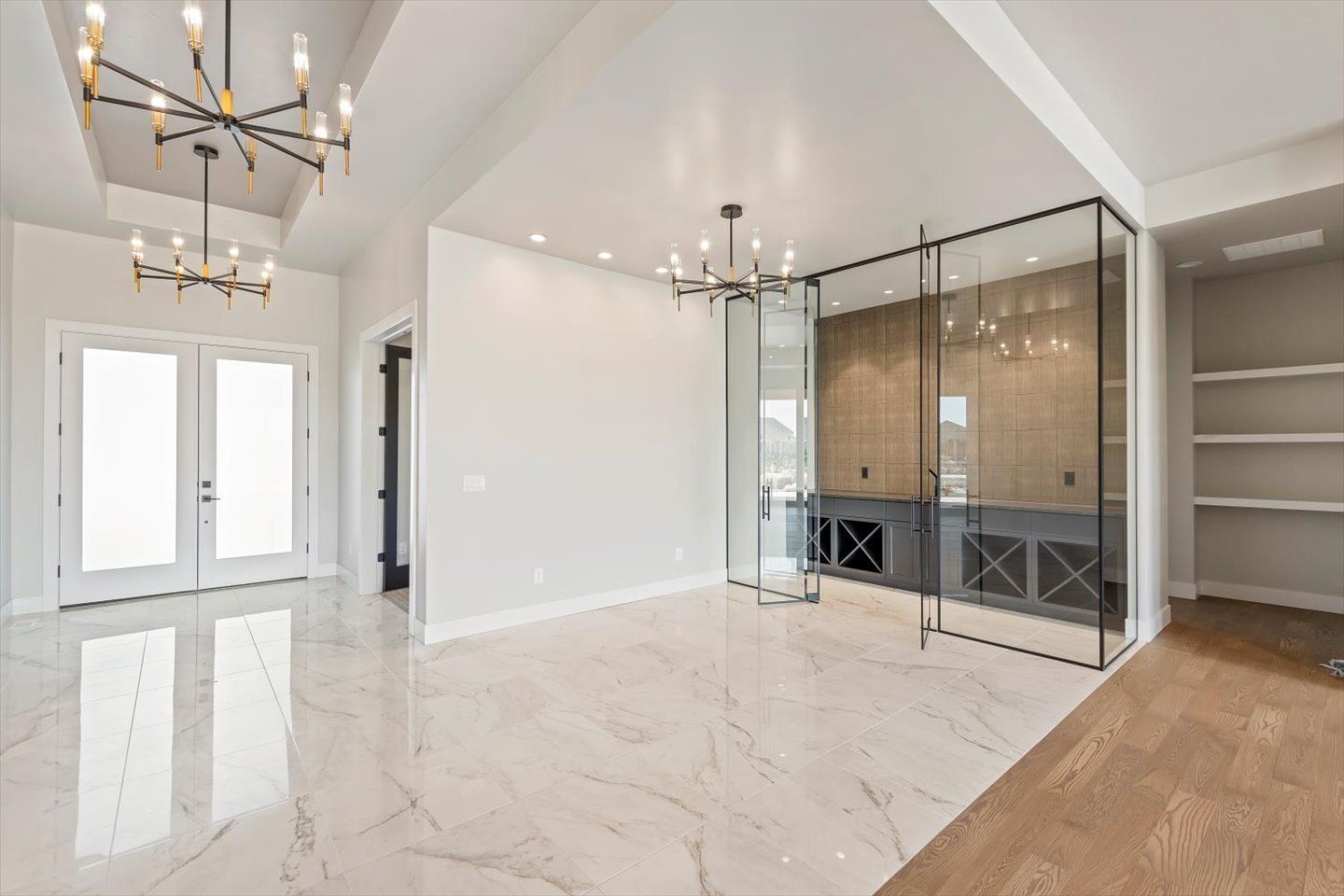 A large empty room with marble floors and a chandelier.