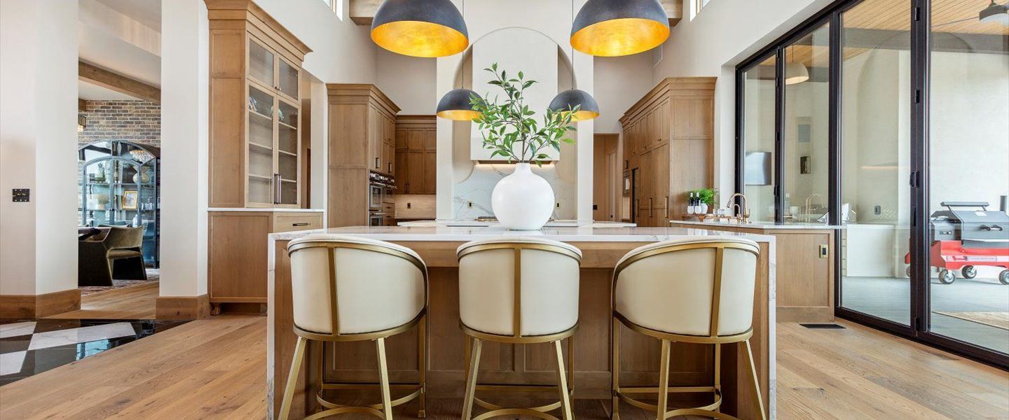 A kitchen with a large island and chairs in it.