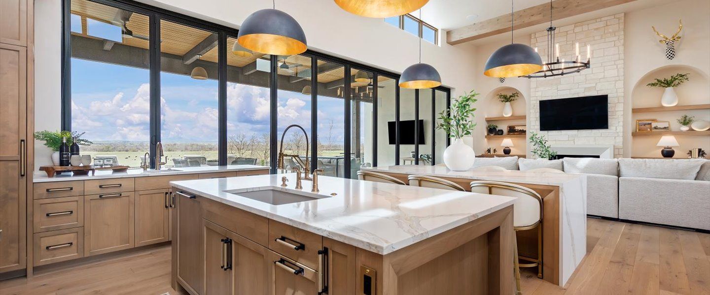 A kitchen with a large island in the middle of it and a lot of windows.