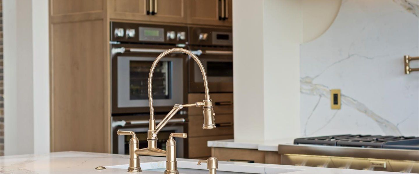 A kitchen with a sink , stove , ovens and a faucet.