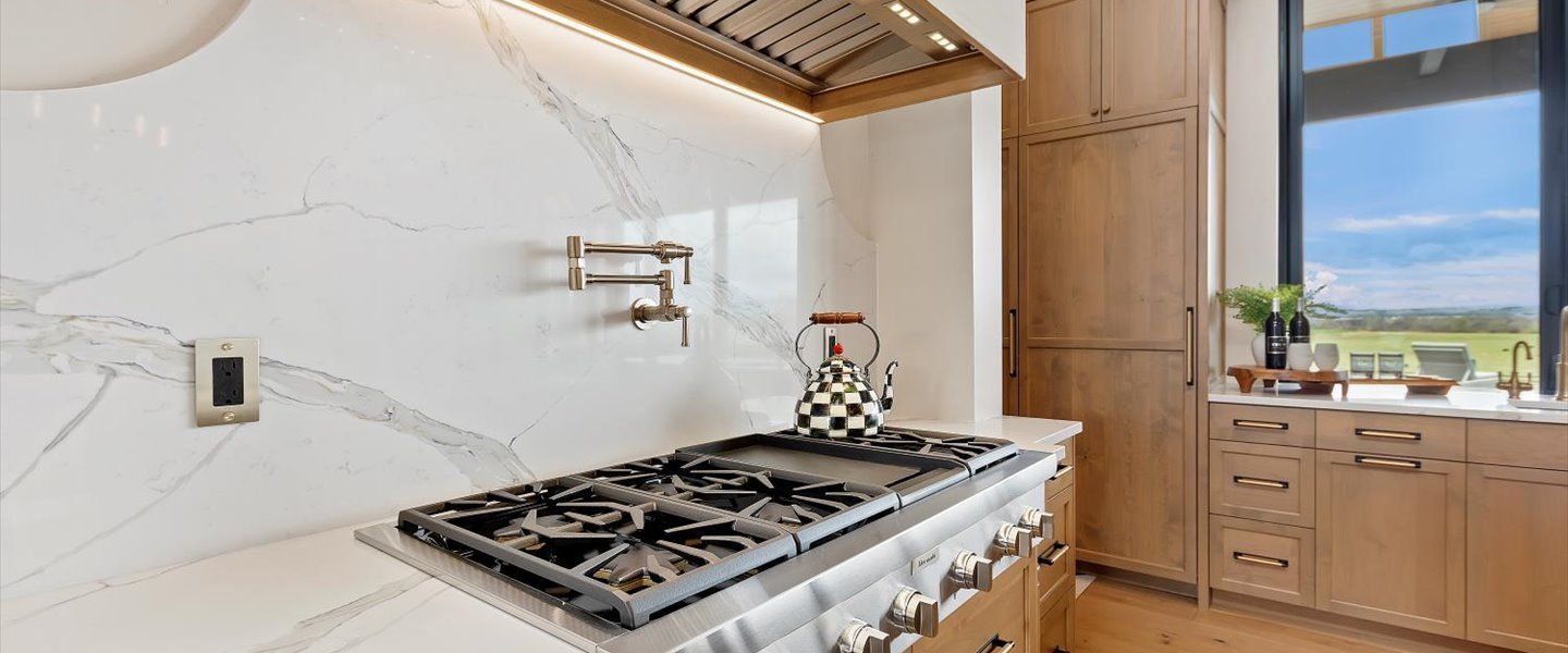 A kitchen with a stove top oven and a window.