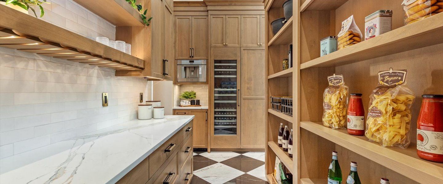 A kitchen with wooden cabinets and shelves filled with food.