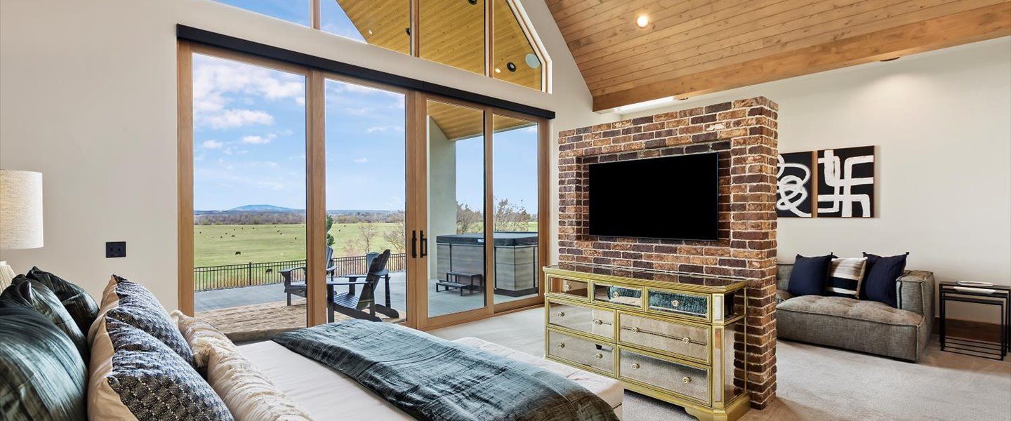 A bedroom with a large bed and a flat screen tv on the wall.