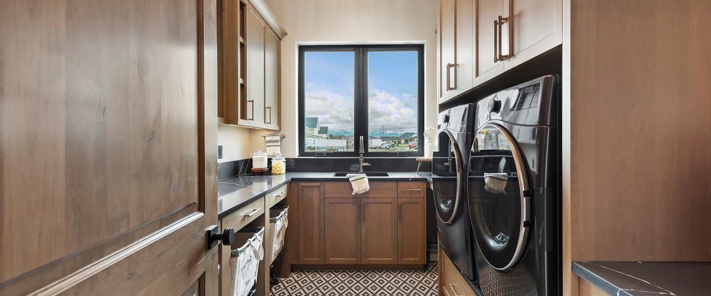 A laundry room with a washer and dryer and a window.