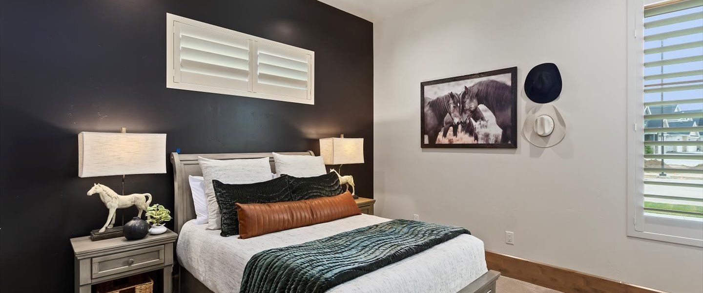 A bedroom with a bed , nightstand , lamps and a picture on the wall.