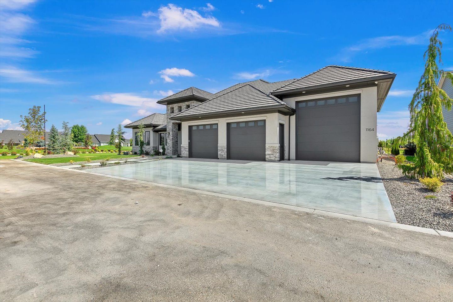 A large house with three garages and a driveway in front of it.