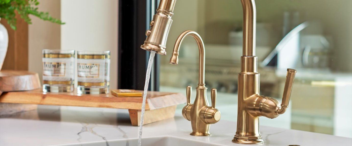 A close up of a kitchen sink with a faucet and water running out of it.