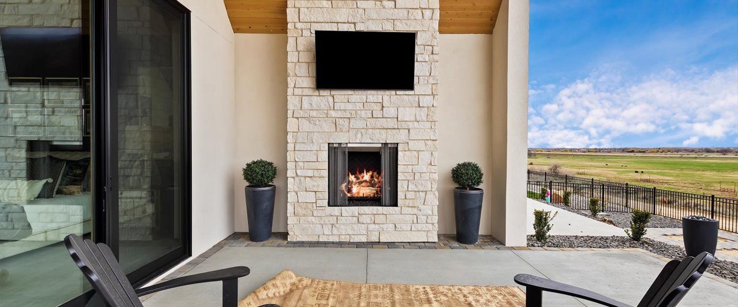 A patio with a fireplace and a flat screen tv.