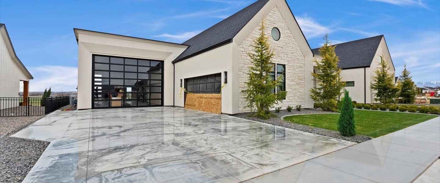 A large white house with a large garage door is for sale.