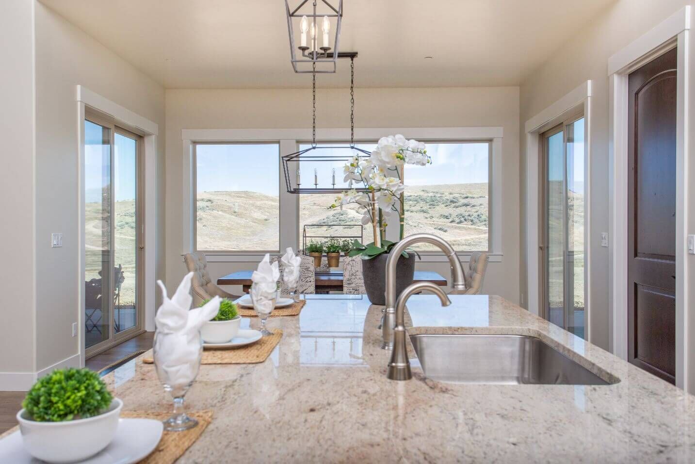 A kitchen with granite counter tops and a stainless steel sink.