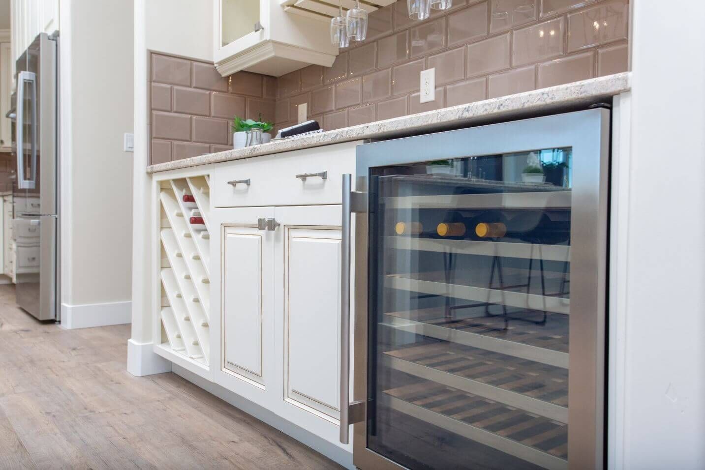 A kitchen with a wine cooler and a wine rack.