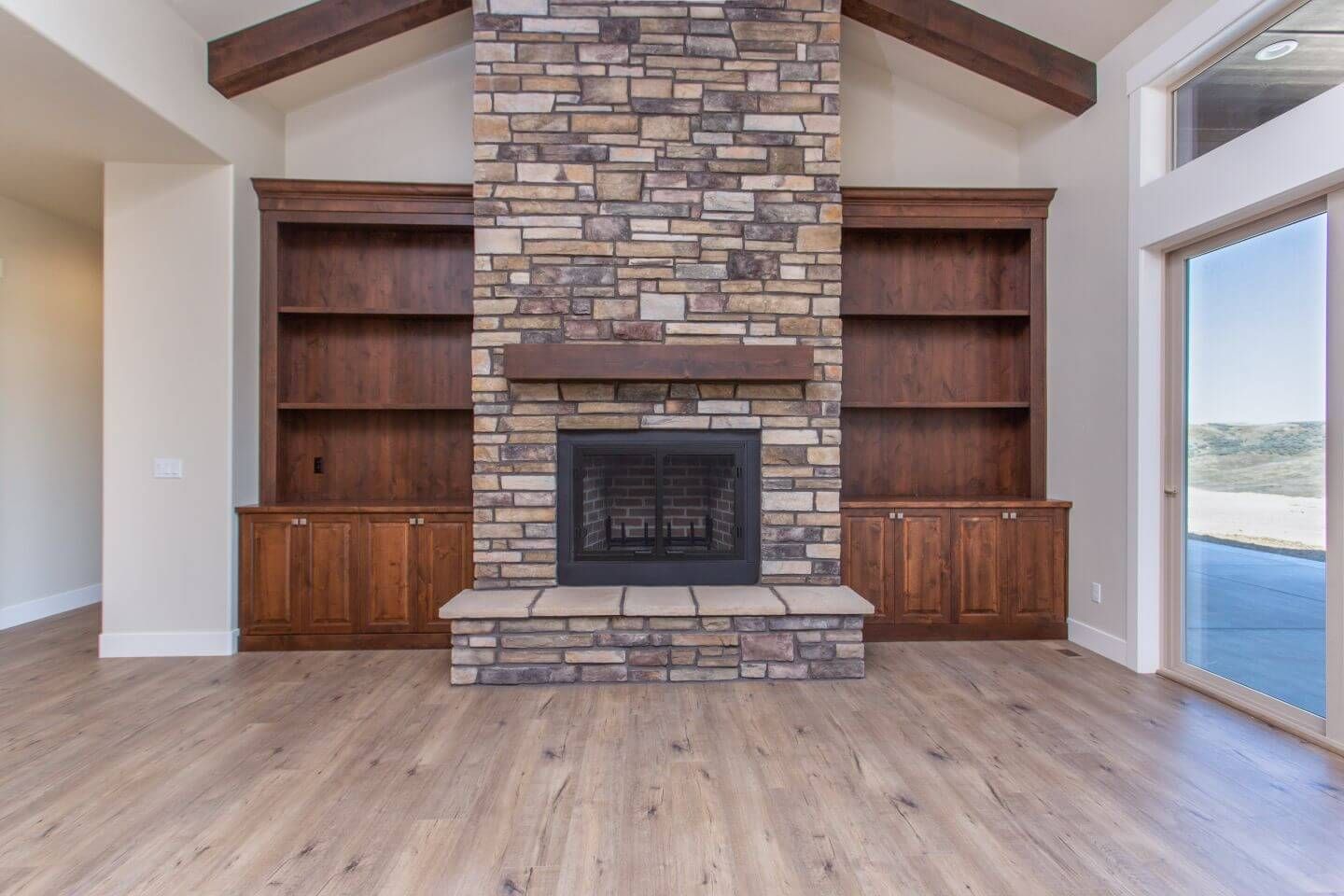 There is a large stone fireplace in the middle of the room.