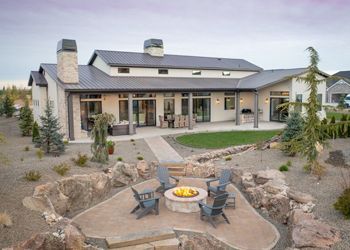 A large house with a fire pit in front of it.