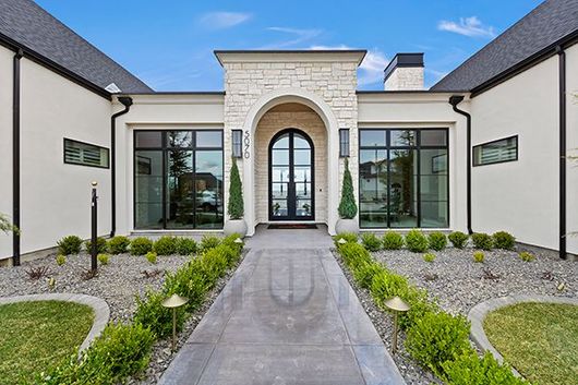 A large white house with a walkway leading to the front door.