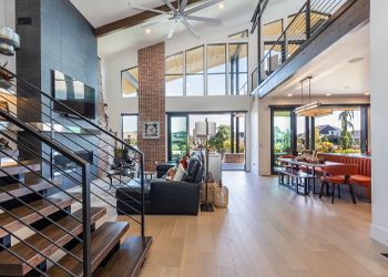 A living room with a staircase leading up to the second floor.
