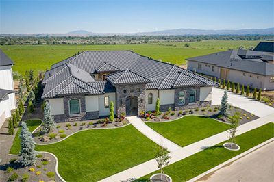 An aerial view of a large house with a lush green lawn.