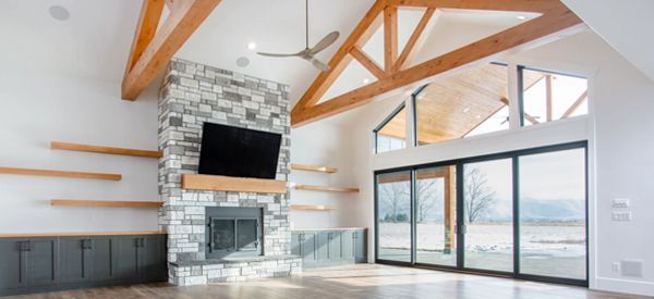 A living room with a fireplace , television , and sliding glass doors.