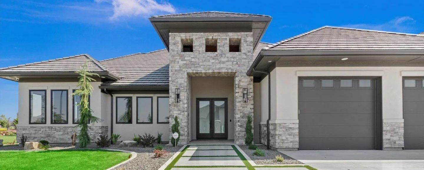 A large house with a lot of windows and a garage.