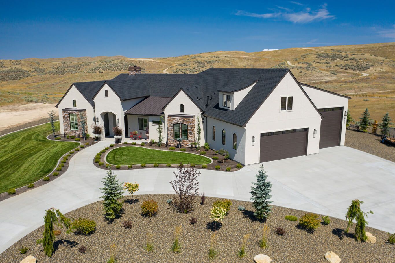 An aerial view of a large house in the middle of a field.