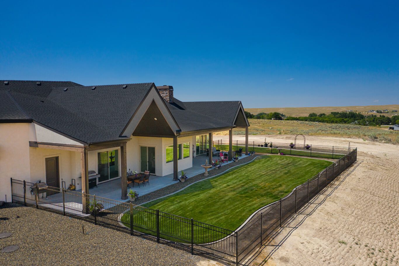 An aerial view of a house with a large lawn in front of it.