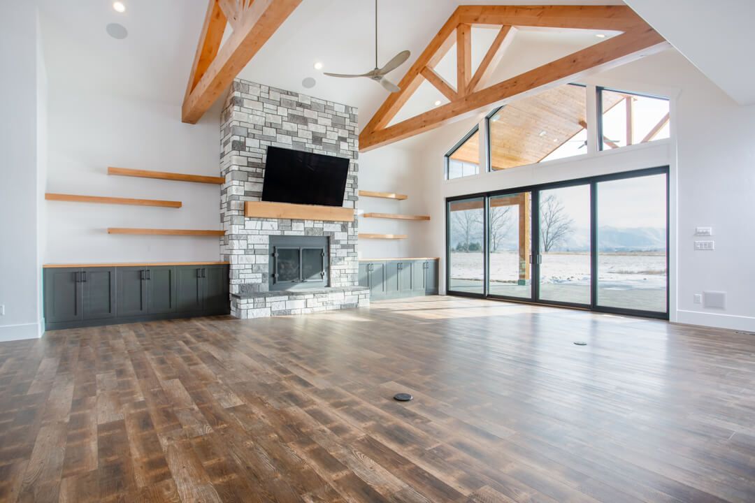 An empty living room with hardwood floors and a fireplace.