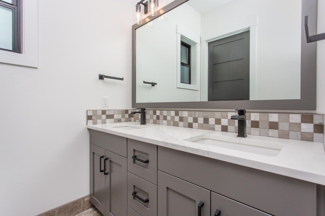 A bathroom with two sinks and a large mirror.