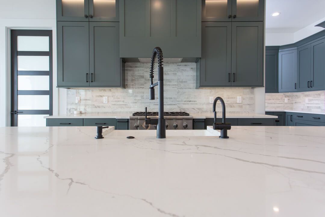 A kitchen with a sink , stove , and cabinets.