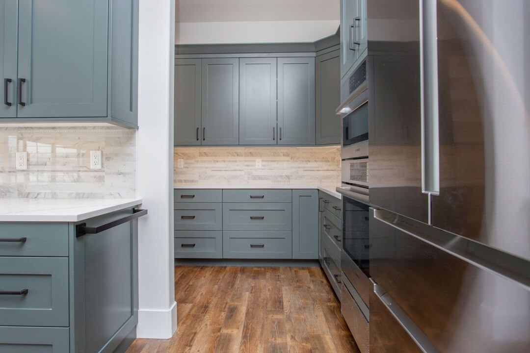 A kitchen with blue cabinets and stainless steel appliances.