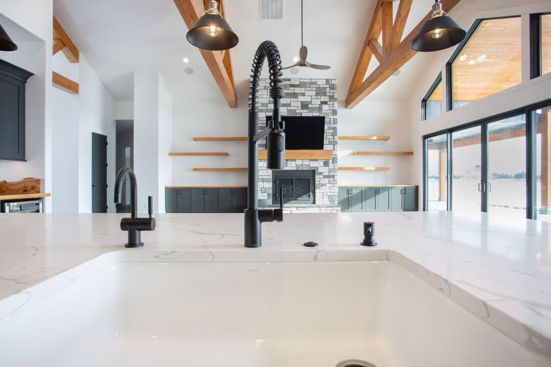 A kitchen with a white sink and a black faucet