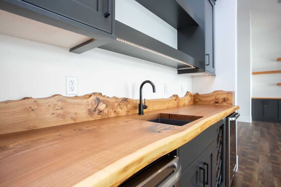 A kitchen with a wooden counter top and a sink.