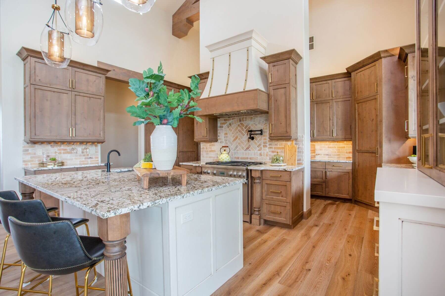 Spacious kitchen with a large island, granite countertop, and wooden cabinets.