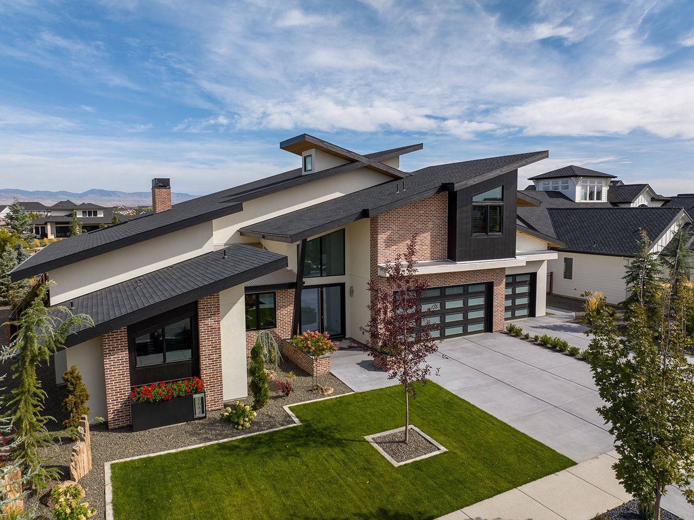 An aerial view of a large house with a large lawn in front of it.