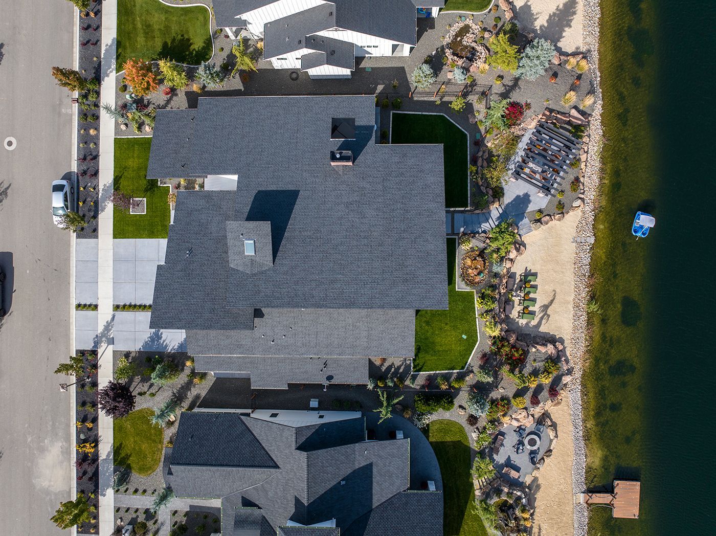 An aerial view of a large house next to a body of water.