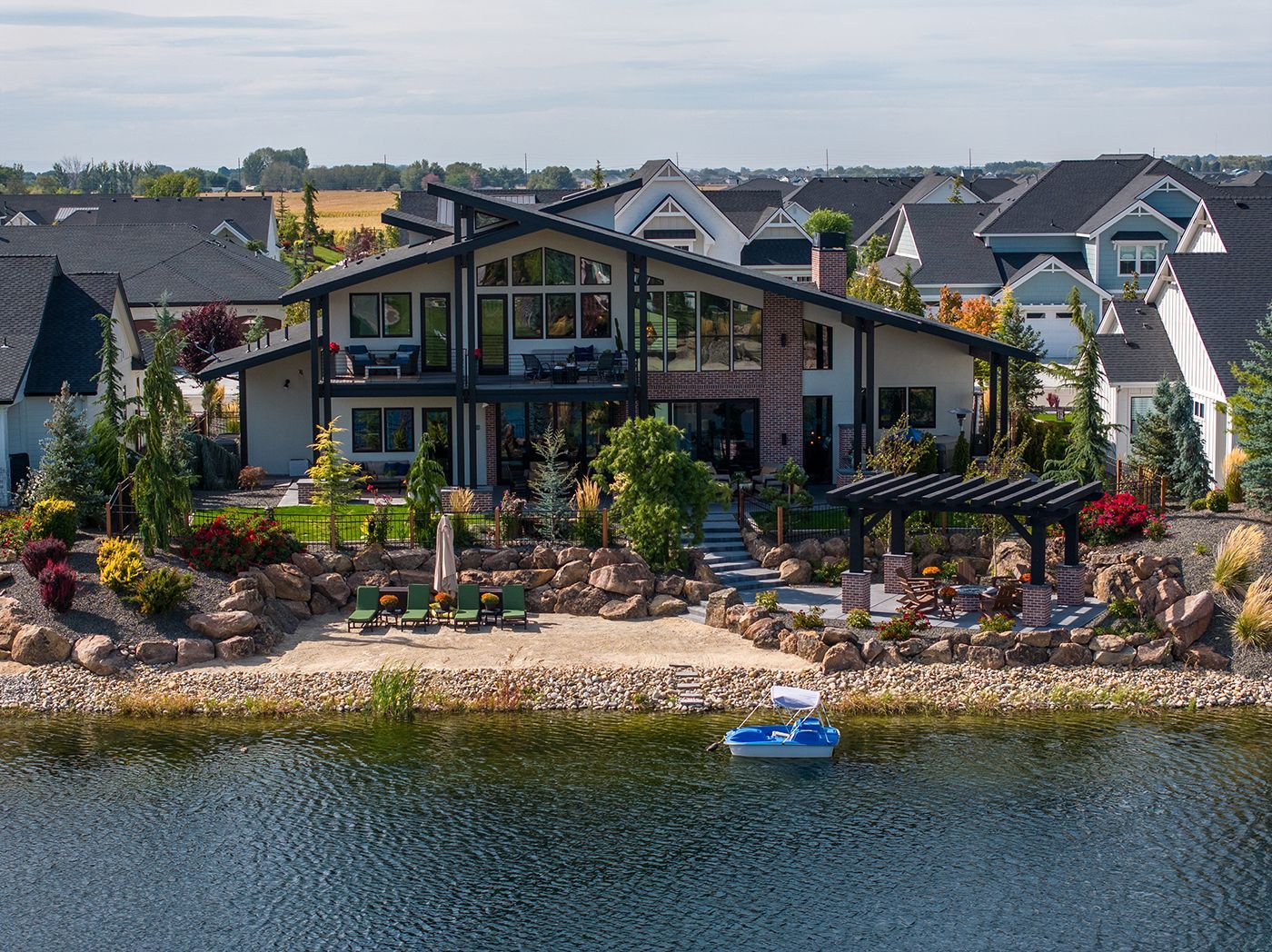 An aerial view of a large house next to a body of water.