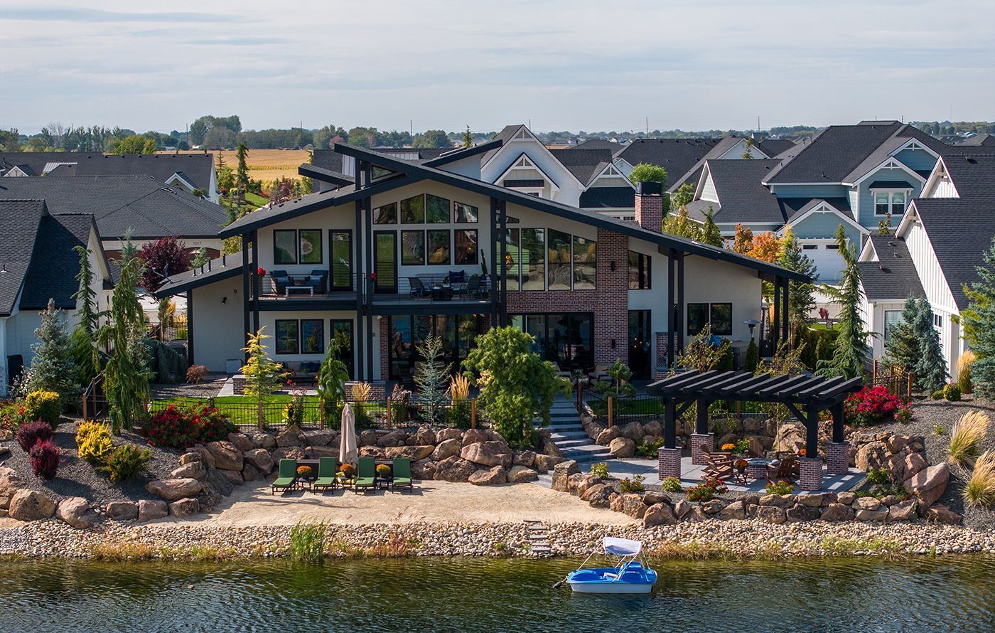 An aerial view of a large house next to a body of water.