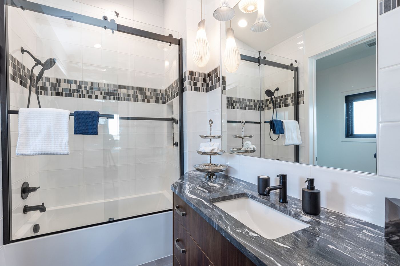 A bathroom with a sink , tub , shower and mirror.